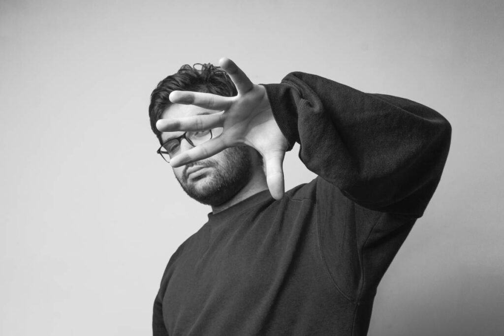 A man pointing hands forward in front black and white