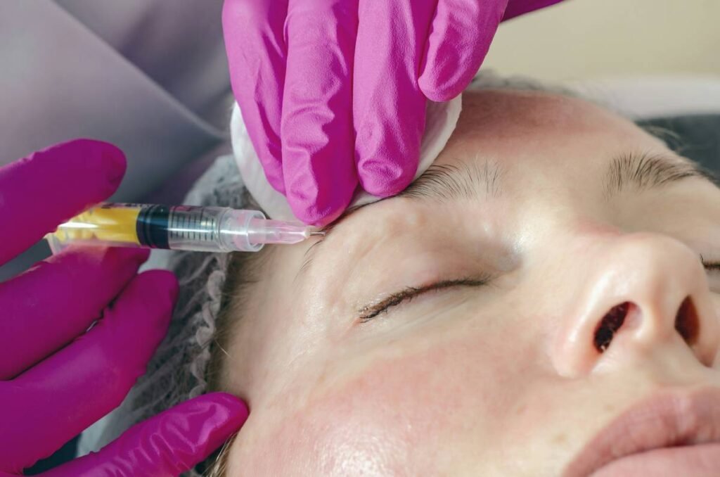 Woman face makes beauty injections around eyes, syringe, medicine, rejuvenation.