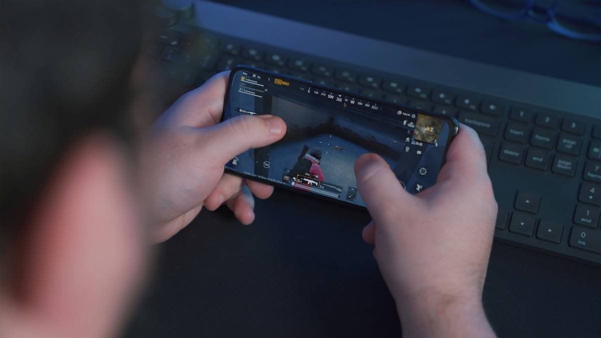 Young man playing PUBG Mobile with phone